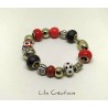 Bracelet en perles tons noirs, rouges, blancs et argentés montées sur fil ressort en métal